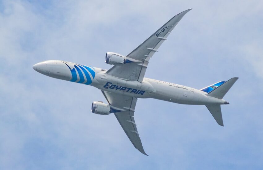 A large jetliner flying through a blue cloudy sky